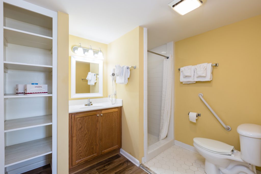 A bathroom with a toilet, sink, and shower.