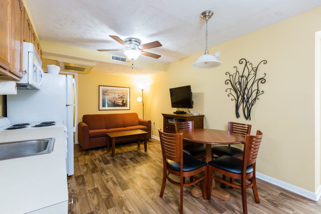 A suite with a kitchenette, dining area, living room, and TV